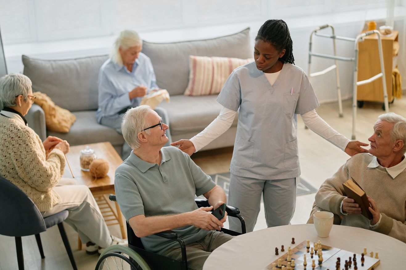 A care worker talking with residents in a bright senior living lounge