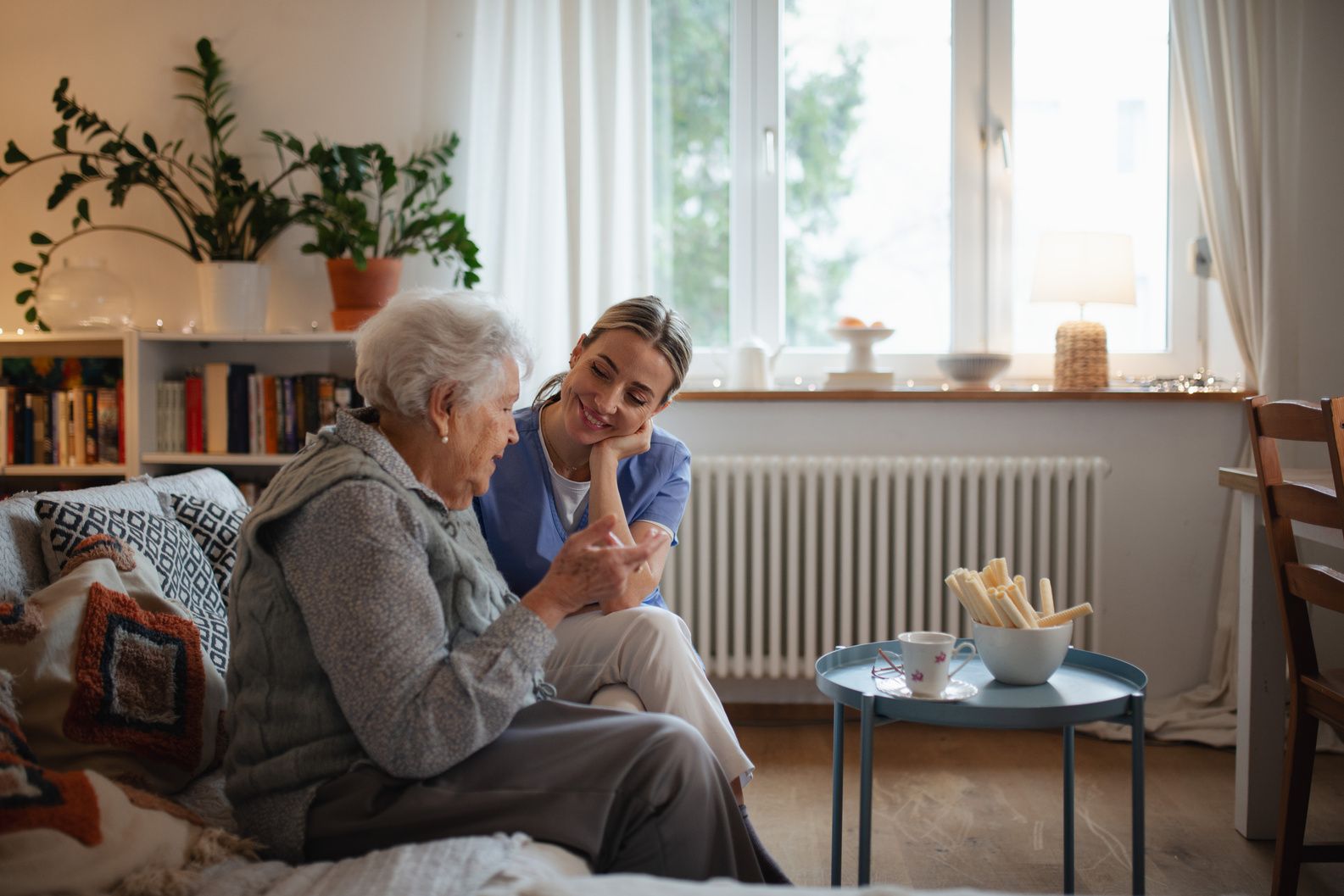 A carer sitting with a resident in her living room