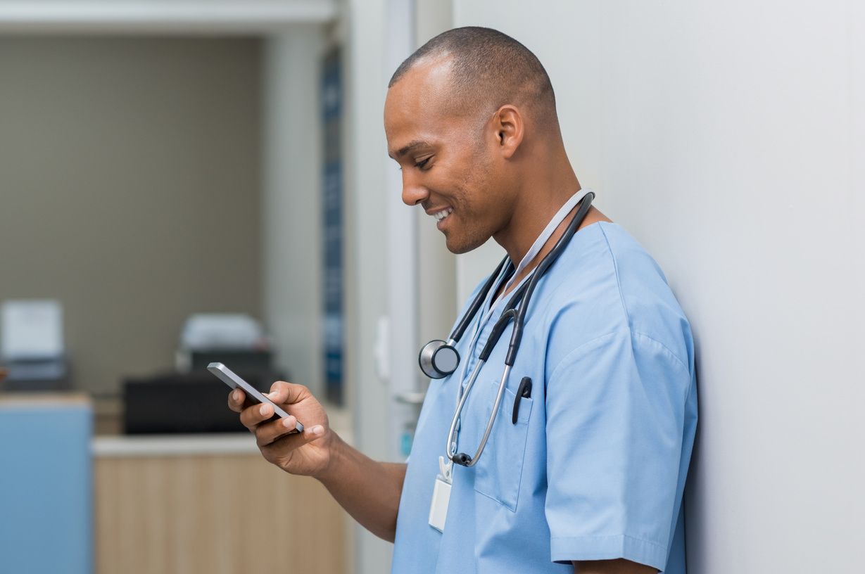 A nurse checking an alert on his phone