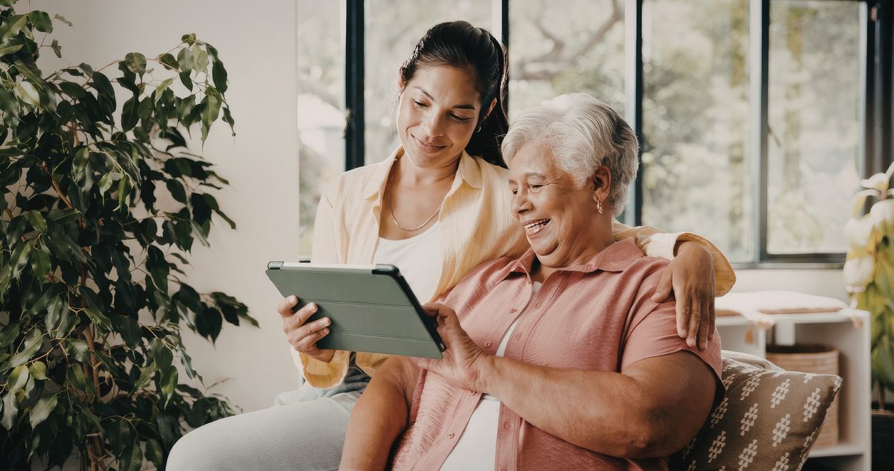 A resident and a care worker looking at a tablet together